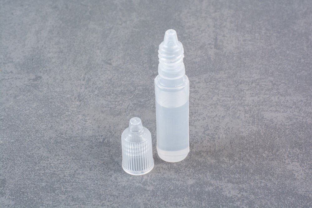 Plastic parts of syringe on marble table.
