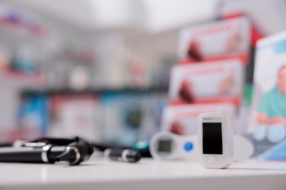 Medical oximeter standing on table in empty drugstore ready to be used by client, digital device to measure oxygen saturation. Pharmacy filled with medicaments, vitamins and pharmaceutical products
